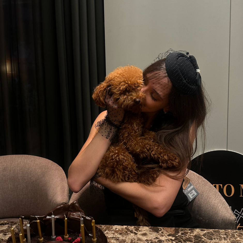 Woman hugging a brown dog in a room.